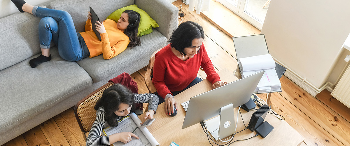 Bird's eye view of family in lounge room using devices